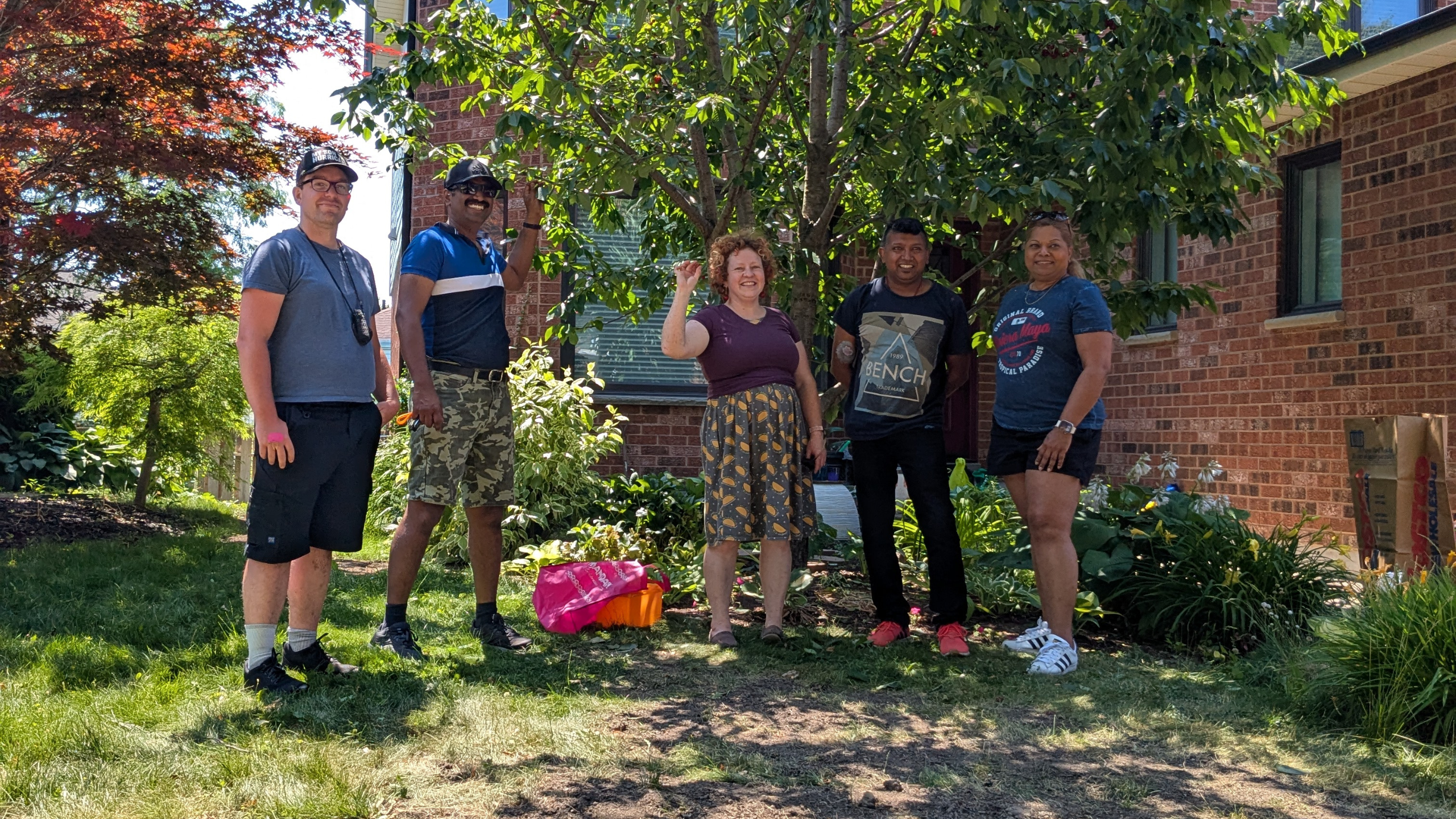 a group of volunteers posing in front of a front yard cherry tree (2025)